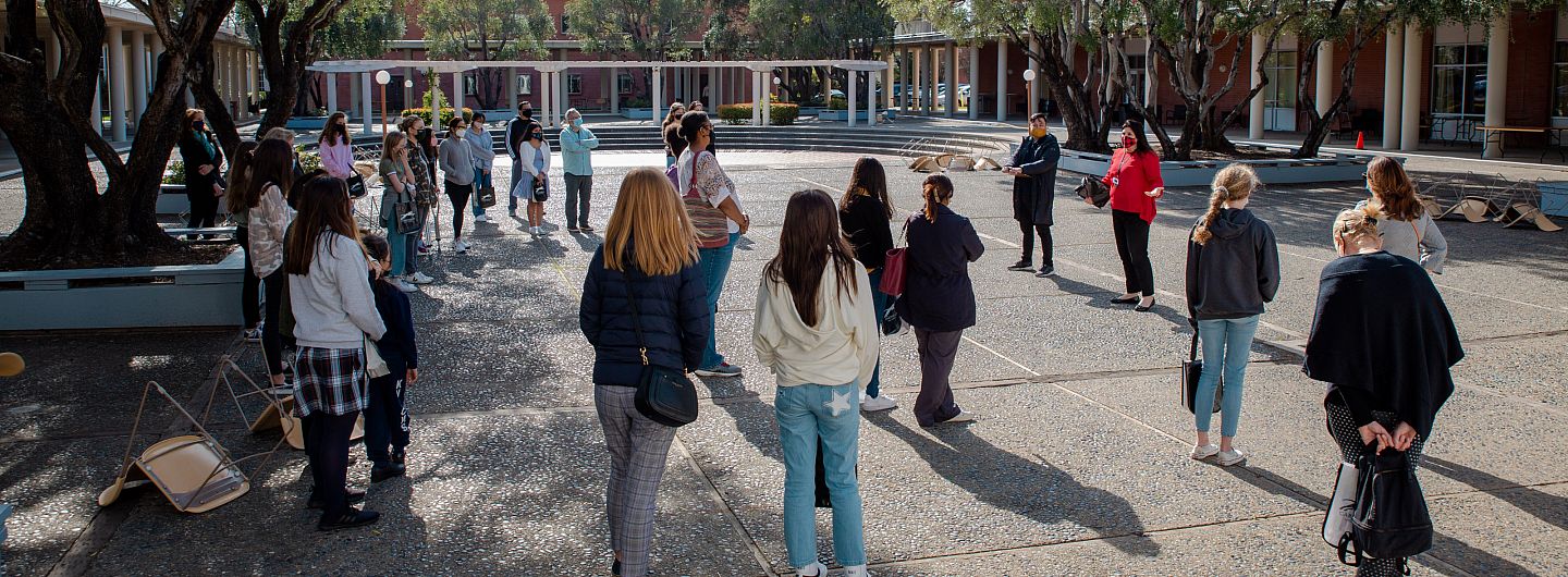 Jessica Mix, Director of Enrollment, leads a tour of two dozen prospective students and parent/guardians in the outdoor Amp.