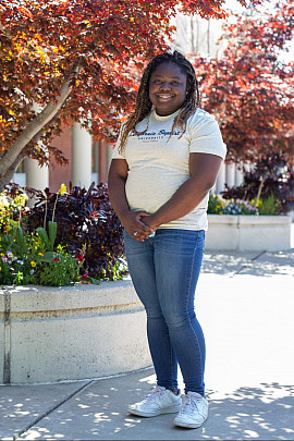Niala Cole '21 stands by a tree near the front of campus.