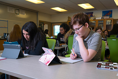 Students work on iPads at tables in Science class
