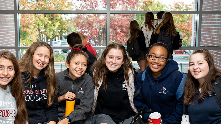 Six students sit with their arms around each other at the Grand Opening of the Jean Hofmann Center for Innovation.